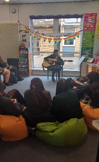 student playing guitar in a library