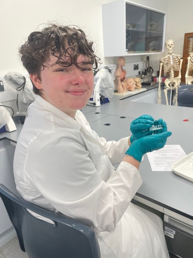smiling student in lab coat